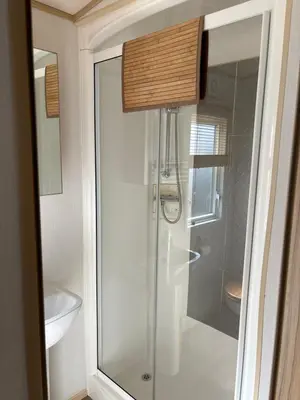 a glass shower in a bathroom with a sink at Squirrel Lodge (Unit 7) in Carlisle