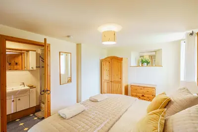 a bedroom with a bed and a sink at The Steading at Castle Creavie Farm in Kirkcudbright