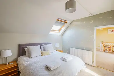 a bedroom with a bed with two towels on it at The Cheeseloft - Spacious one bed with terrace in Kirkcudbright