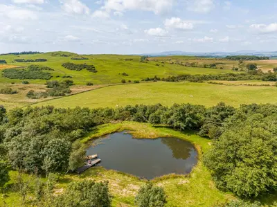 an aerial view of a lake in a field at The Cheeseloft - Spacious one bed with terrace in Kirkcudbright