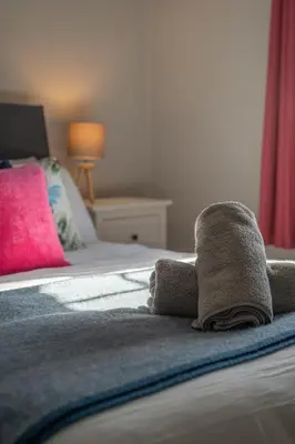 a bed with towels sitting on top of it at Gatesgarth Cottage @ The Pheasant Inn in Brampton