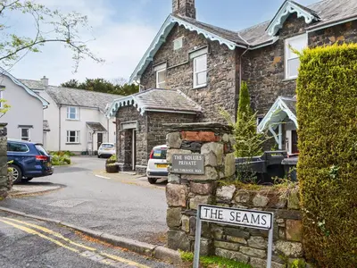 a street sign in front of a stone house at Six The Hollies in Keswick