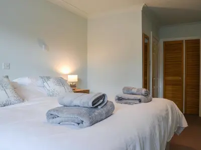 a bedroom with a white bed with towels on it at Six The Hollies in Keswick