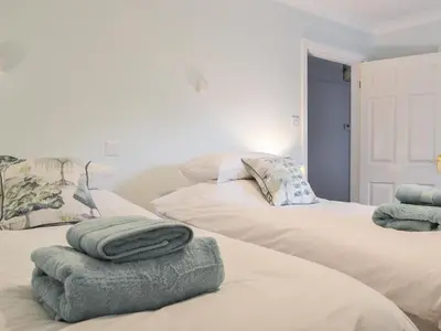 two beds with towels on top of them in a room at Six The Hollies in Keswick