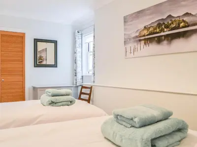 a bedroom with two beds with towels on them at Six The Hollies in Keswick