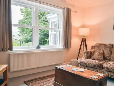 a living room with a chair and a window at Six The Hollies in Keswick