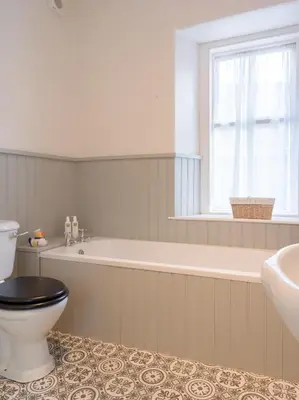 a bathroom with a tub and a toilet and a sink at Yewthwaite Newlands Keswick in Keswick