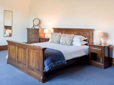 a bedroom with a large wooden bed and two night stands at Yewthwaite Newlands Keswick in Keswick