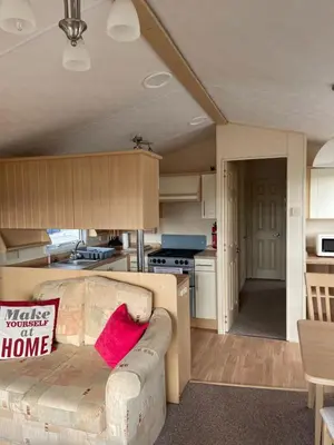 a living room with a couch and a kitchen at Beautiful 2-Bed Static caravan in Newton Stewart