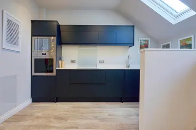 a large kitchen with blue cabinets and a sink at Howe Keld 4 First floor in Keswick