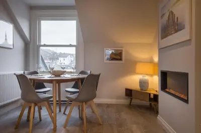 a dining room with a table and chairs and a tv at Howe Keld 4 First floor in Keswick