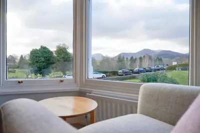 a room with two chairs and a table and a large window at Howe Keld 4 First floor in Keswick