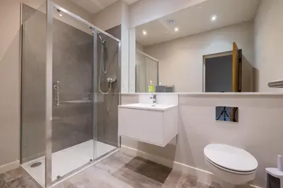 a bathroom with a shower and a toilet and a sink at Howe Keld 5 First Floor in Keswick