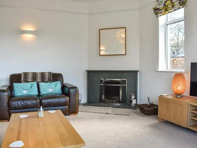 a living room with a couch and a fireplace at Littlethwaite in Keswick
