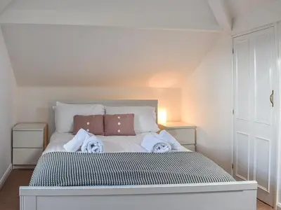 a bedroom with a white bed with towels on it at Littlethwaite in Keswick