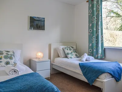 a bedroom with two beds and a window at Littlethwaite in Keswick