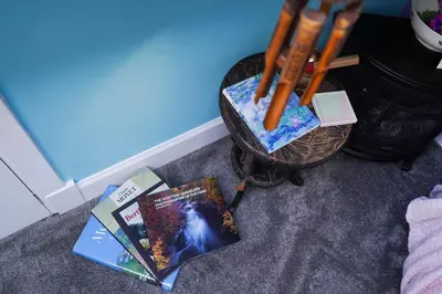 two books sitting on the floor next to a basket at The Art Bank in Dalbeattie