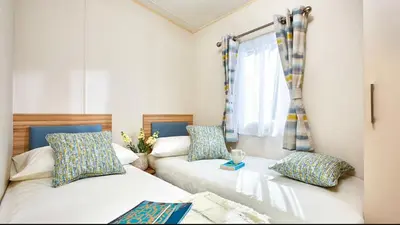 a room with two beds and a window at AJL Caravan Rentals in Turnberry