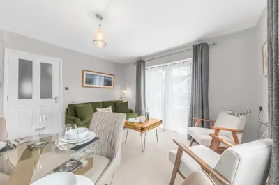 a living room with a green couch and a table at Derwent Cottage in Keswick