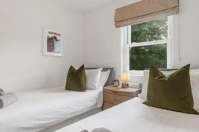 a bedroom with two beds and a window at Derwent Cottage in Keswick