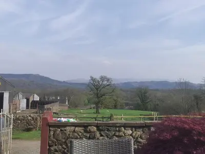 a stone wall with a golf course in the background at Rainors farm B&B in Gosforth