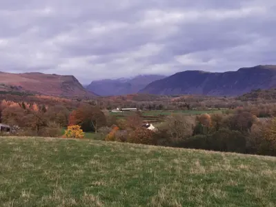 a view of a field with mountains in the background at Rainors farm B&B in Gosforth