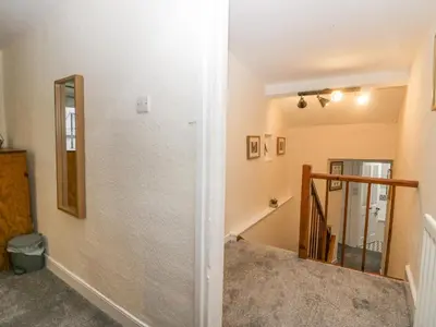 a hallway with a mirror and a staircase in a house at Nook Cottage in Keswick