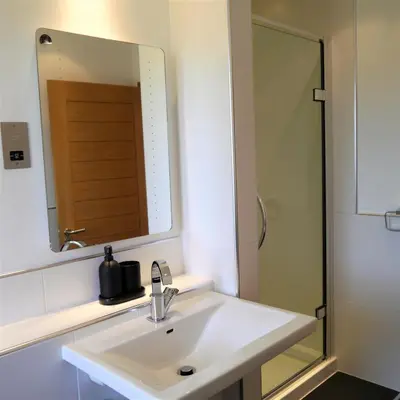 a bathroom with a sink and a mirror and a shower at Annapurna in Portpatrick