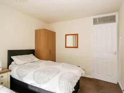 a bedroom with a bed and a wooden cabinet at Noble Knott in Keswick
