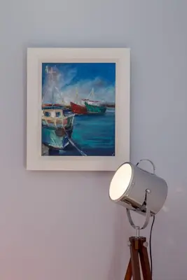a painting of boats on a wall with a lamp at Carlton House Portpatrick in Portpatrick