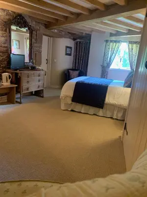 a bedroom with a bed and a desk and a television at Fiddleback Farm in Wigton