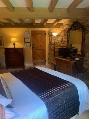 a bedroom with a large bed and a mirror at Fiddleback Farm in Wigton
