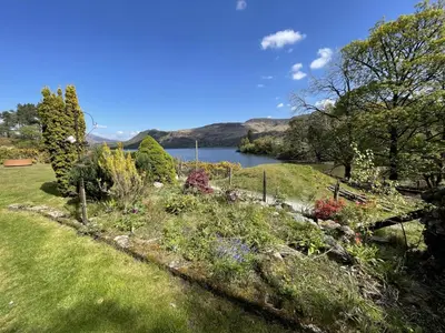 a garden with a view of a lake at Brandlehow HOT TUB HIRE AVAILABLE in Portinscale