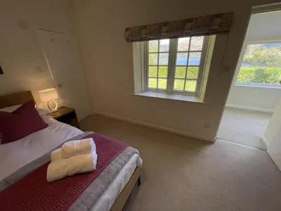 a bedroom with a bed and a window at Brandlehow HOT TUB HIRE AVAILABLE in Portinscale