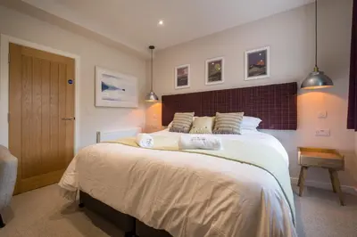 a bedroom with a large bed with two towels on it at Howe Keld 1 Ground floor in Keswick