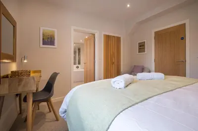 a bedroom with a bed with a desk and a chair at Howe Keld 1 Ground floor in Keswick