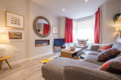 a living room with a couch and a tv at Howe Keld 1 Ground floor in Keswick