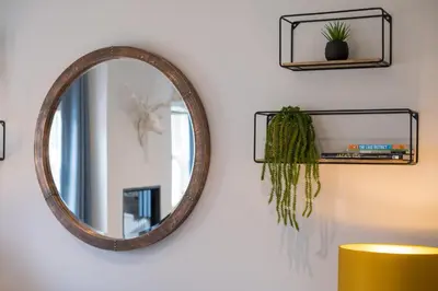 a mirror hanging on a wall with a plant at Howe Keld 3 Ground floor in Keswick