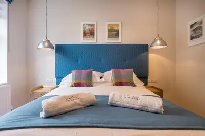 a bedroom with a bed with two pillows on it at Howe Keld 3 Ground floor in Keswick