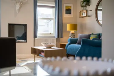 a living room with a blue couch and a table at Howe Keld 3 Ground floor in Keswick
