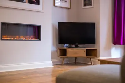 a living room with a tv and a fireplace at Howe Keld 2 Ground Floor in Keswick