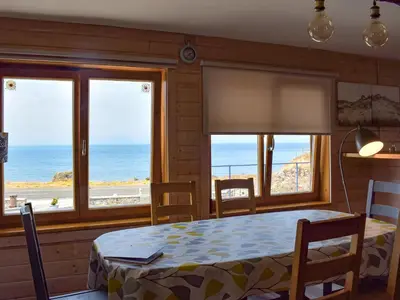 a dining room with a table and views of the ocean at Seal Rocks in Lendalfoot