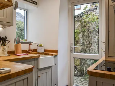 a kitchen with a door leading to a garden at Pollywiggle Cottage in Keswick