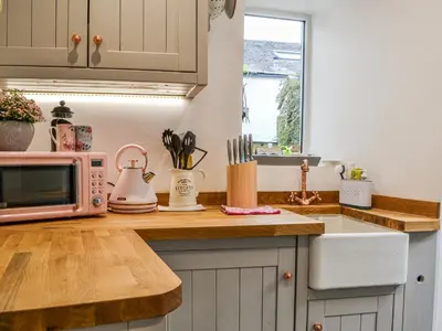 a kitchen with a counter top with a microwave at Pollywiggle Cottage in Keswick
