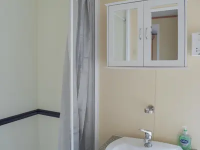 a bathroom with a sink and a medicine cabinet at Tranquillity Lodge in Annbank