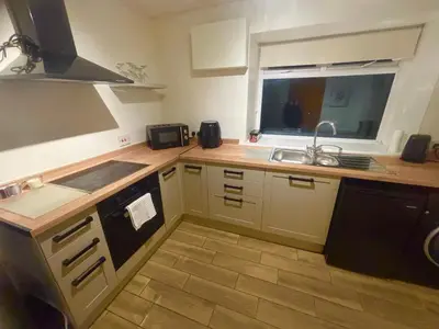 a small kitchen with a sink and a stove at AIRDSIDE COTTAGE in Castle Douglas