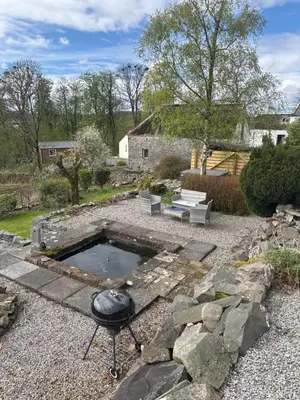 a backyard with a grill and a fire pit at AIRDSIDE COTTAGE in Castle Douglas