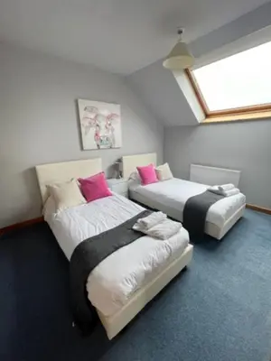 a room with two beds and a window at AIRDSIDE COTTAGE in Castle Douglas
