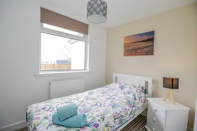 a bedroom with a bed and a window at The Wigwam in Dumfries