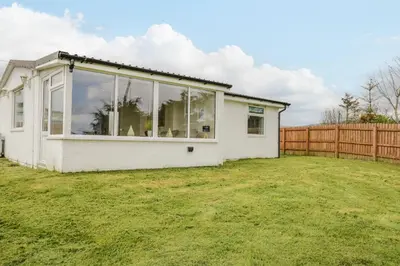 a white house with large windows in a yard at The Wigwam in Dumfries